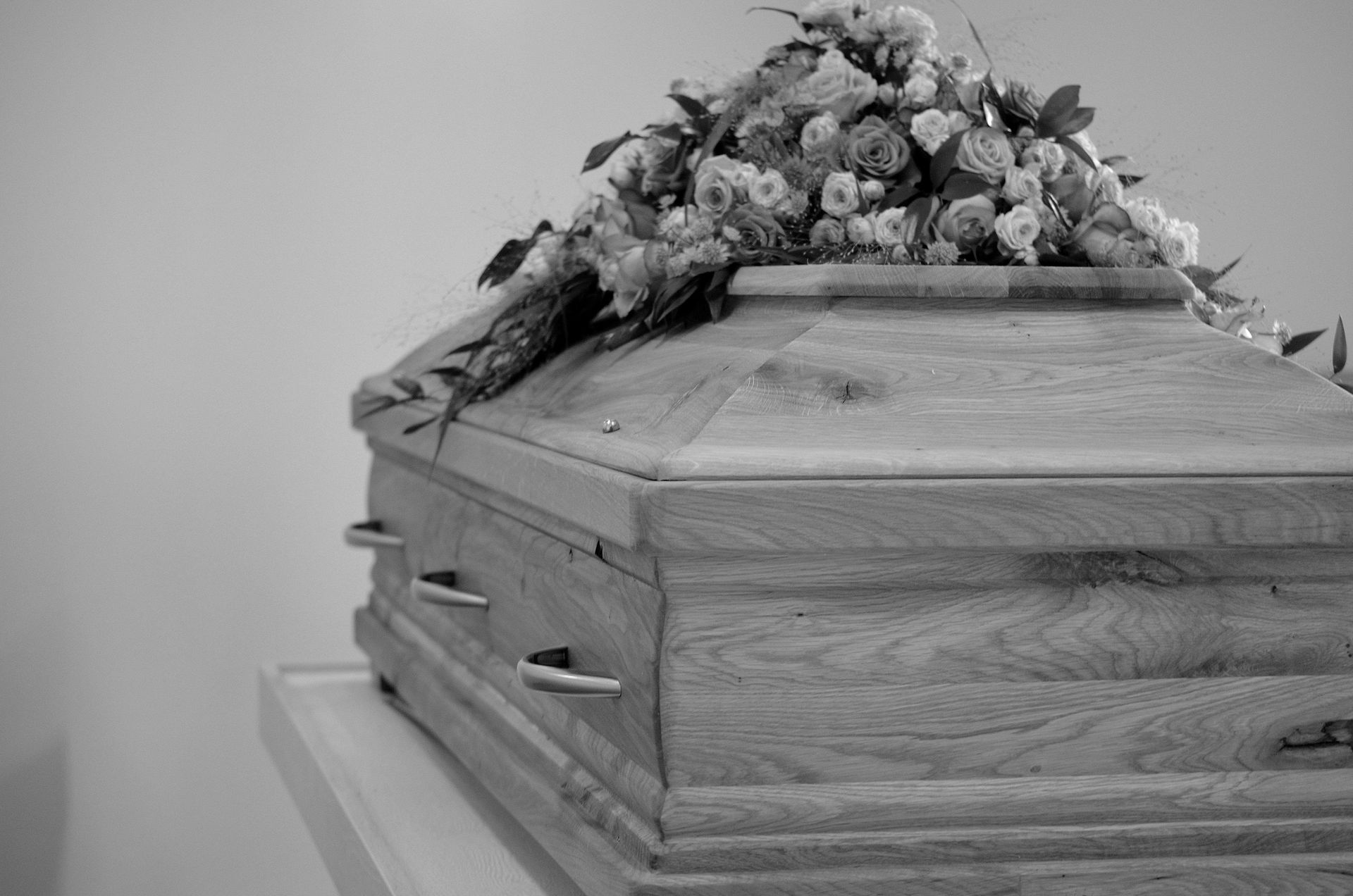coffin with flowers on top, black and white 