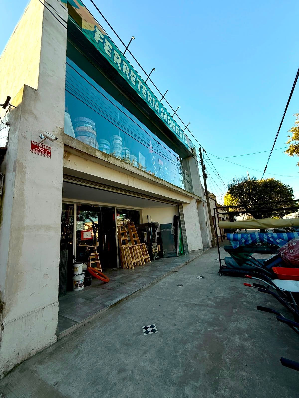 Tres personas charlando en una moderna tienda de electrónica con ordenadores portátiles y accesorios en exposición.