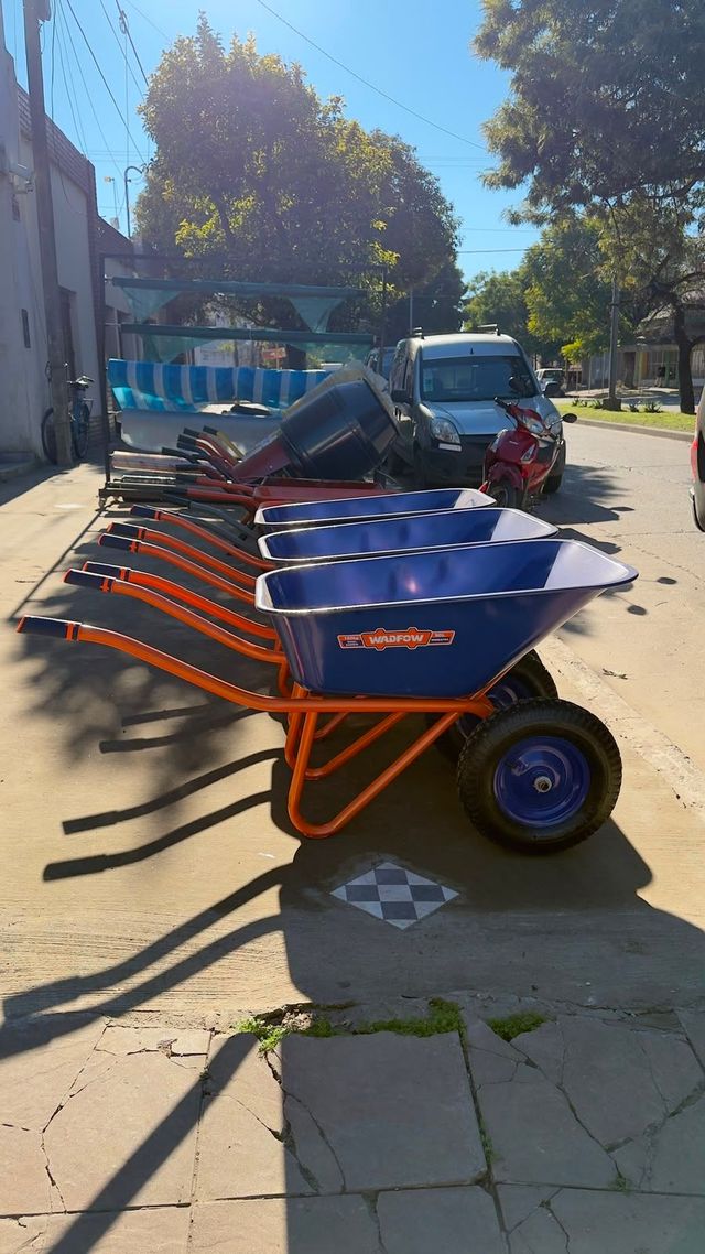 Pasillo con accesorios de plomería de acero inoxidable en estantes de una tienda, visto desde el centro.