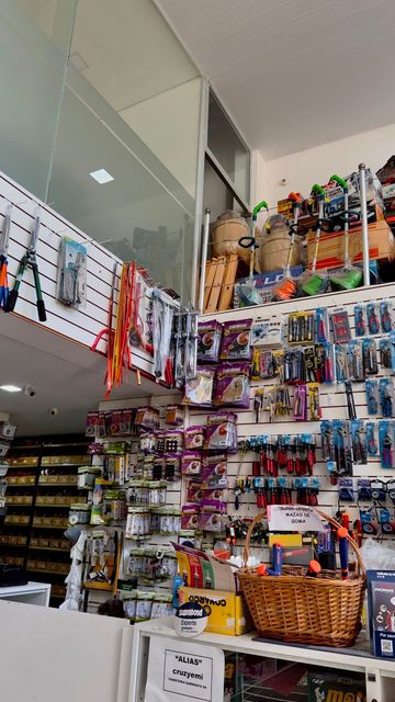 Estanterías repletas de coloridos artículos de artesanía y regalo en el interior de una pequeña tienda.