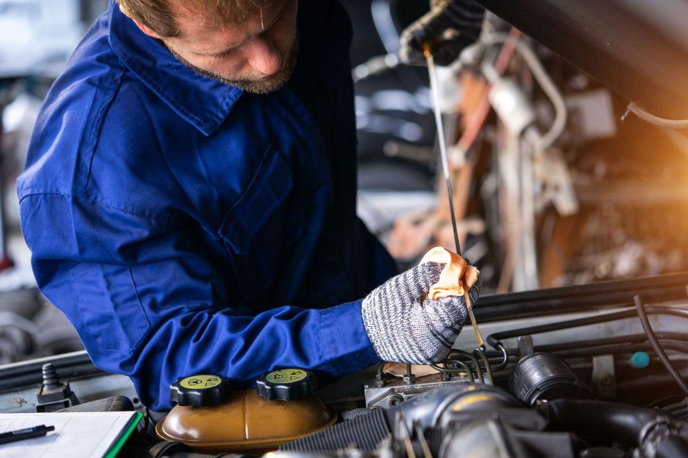 A man is working on a car engine in a garage.