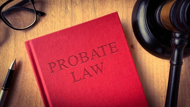 Probate law book with gavel, glasses, and pen on a wooden table at Stephenson & Stephenson PA Attorneys at Law in Pittsboro, NC.