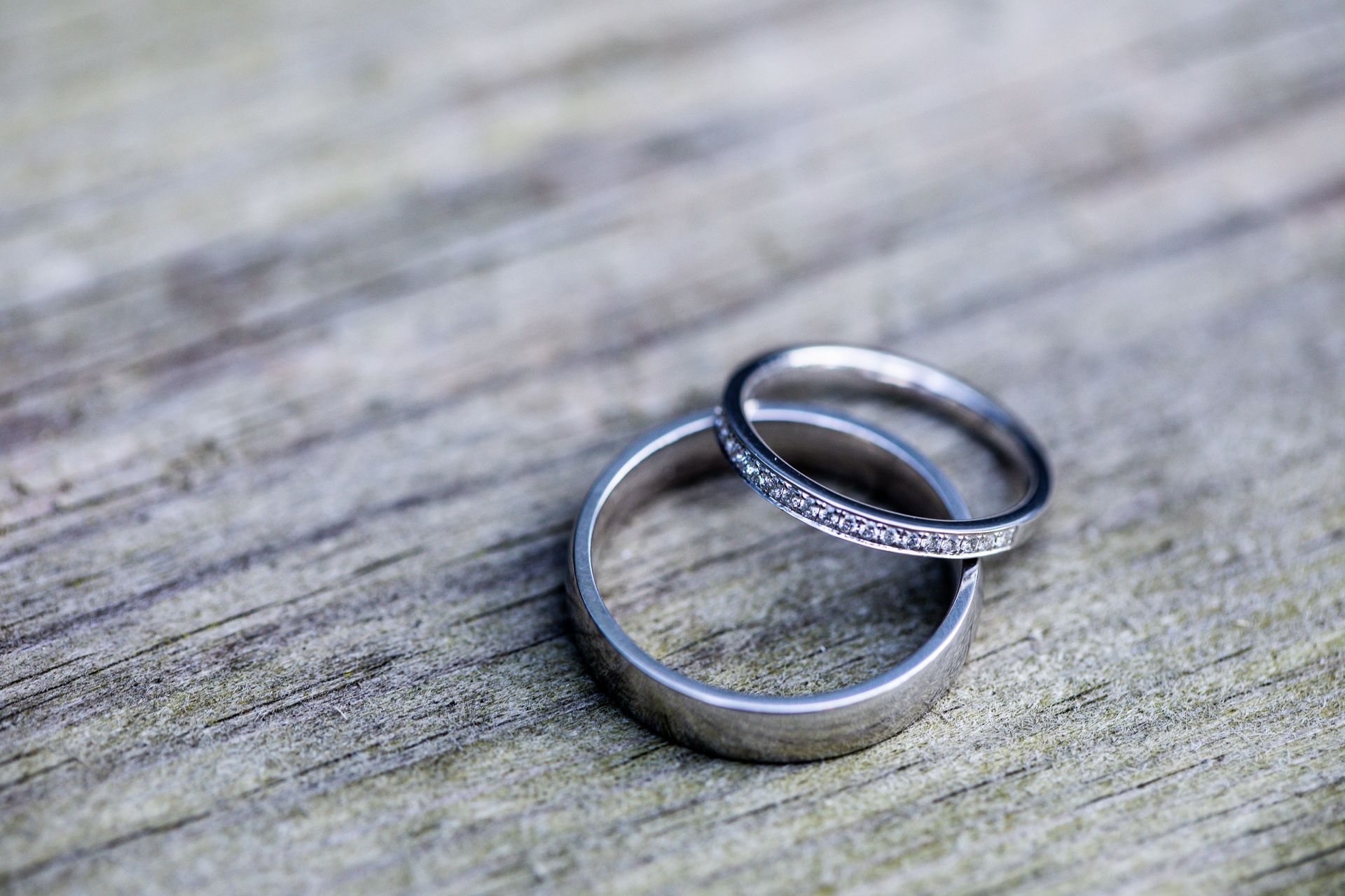 Two silver rings overlapping on a weathered wooden surface