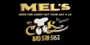 Mel’s restaurant sign with “We Cook for Groups,” carryout hours, and phone number 870-578-5153