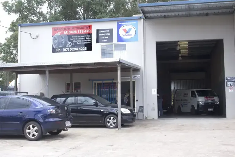 Auto Repair Shop with Two Cars Parked Outside and One Vehicle Inside a Garage Bay — Maroochy Automotive in Kunda Park, QLD