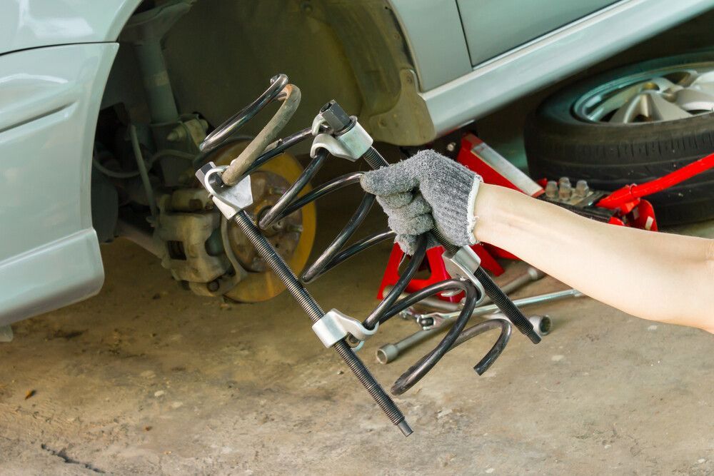 A Person is Holding a Tool in Front of a Car — Maroochy Automotive in Kunda Park, QLD