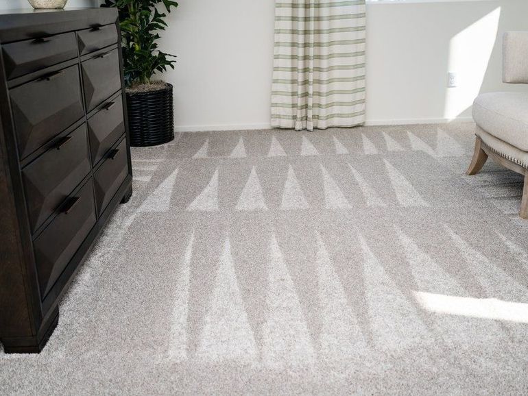 a living room with a rug and a dresser
