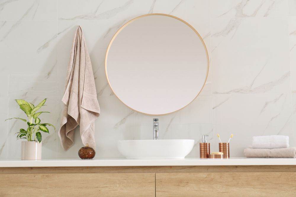 A Bathroom With A Sink, Mirror And Towels Hanging On The Wall — InStyle Shower Screens & Wardrobes in Lake Macquarie, NSW
