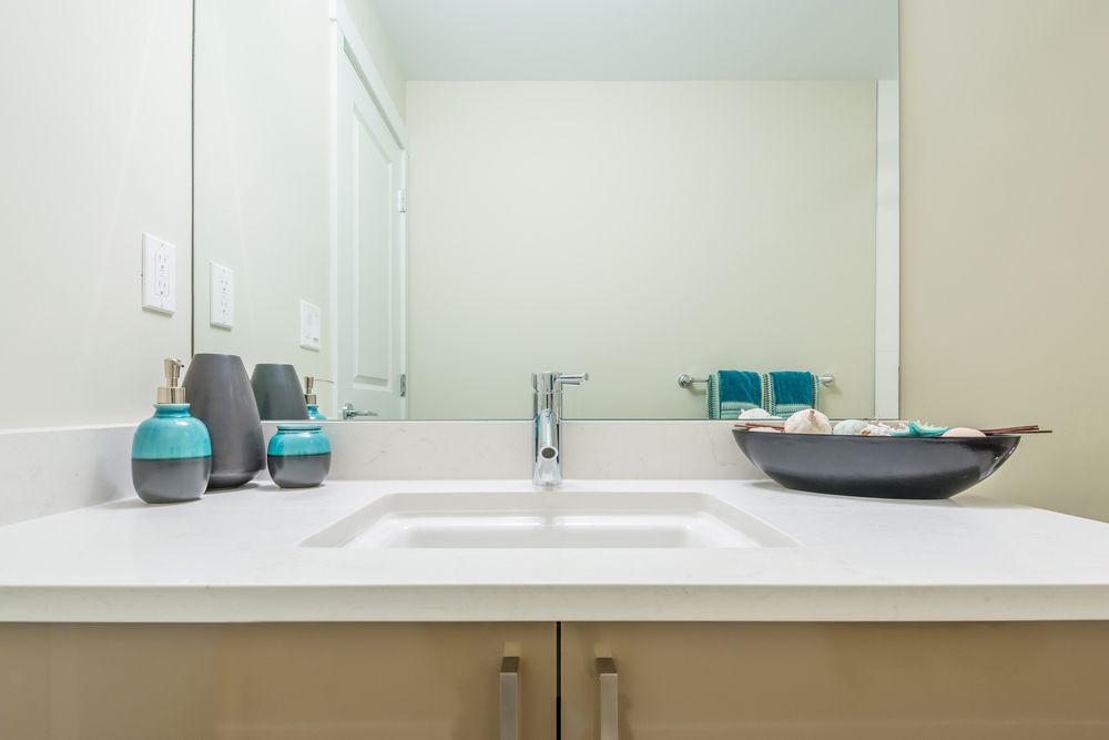 A Bathroom With A Sink, Mirror And Vases On The Counter — InStyle Shower Screens & Wardrobes in Gosford, NSW