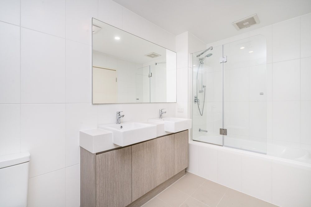 A Bathroom With Two Sinks, A Shower And A Bathtub — InStyle Shower Screens & Wardrobes in Gosford, NSW