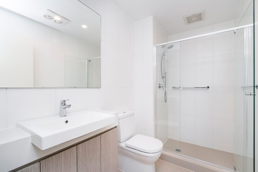 A Bathroom With A Toilet, Sink And Shower — InStyle Shower Screens & Wardrobes in Gosford, NSW