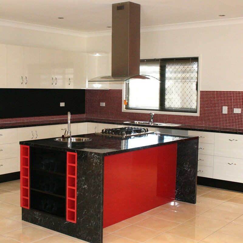 A Large Kitchen With Island In The Middle Having Red and Black tiles — Leader Constructions in Cranbrook, QLD