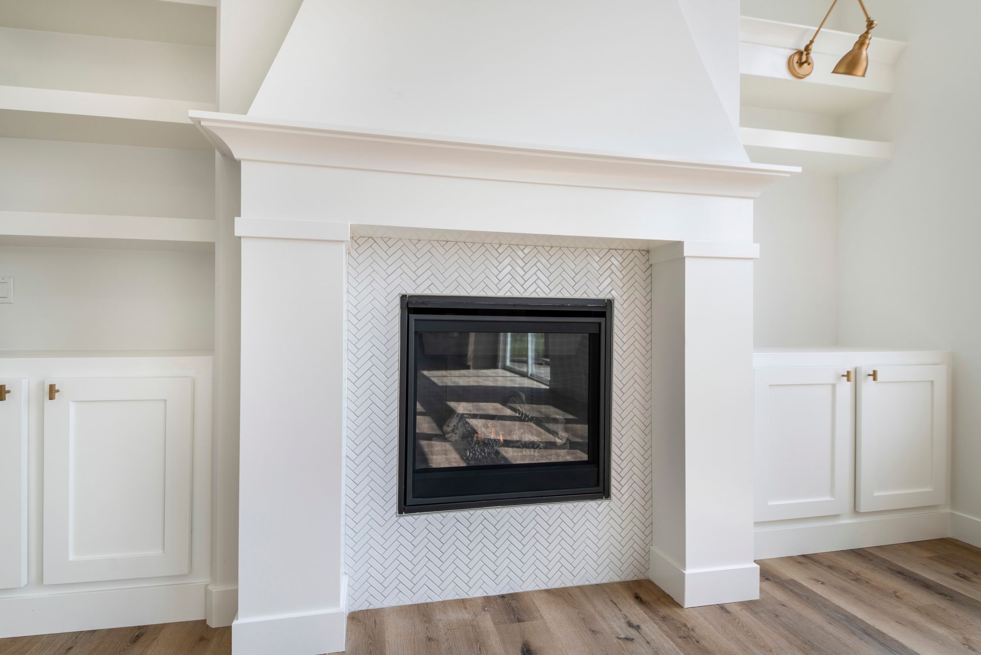 White living room fireplace with built-in cabinets and wood flooring White living room fireplace with built-in cabinets and wood flooring