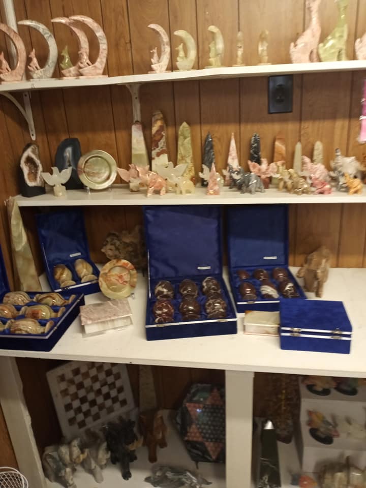 Shelves of decorative figurines and trinkets in blue boxes inside a shop display cabinet