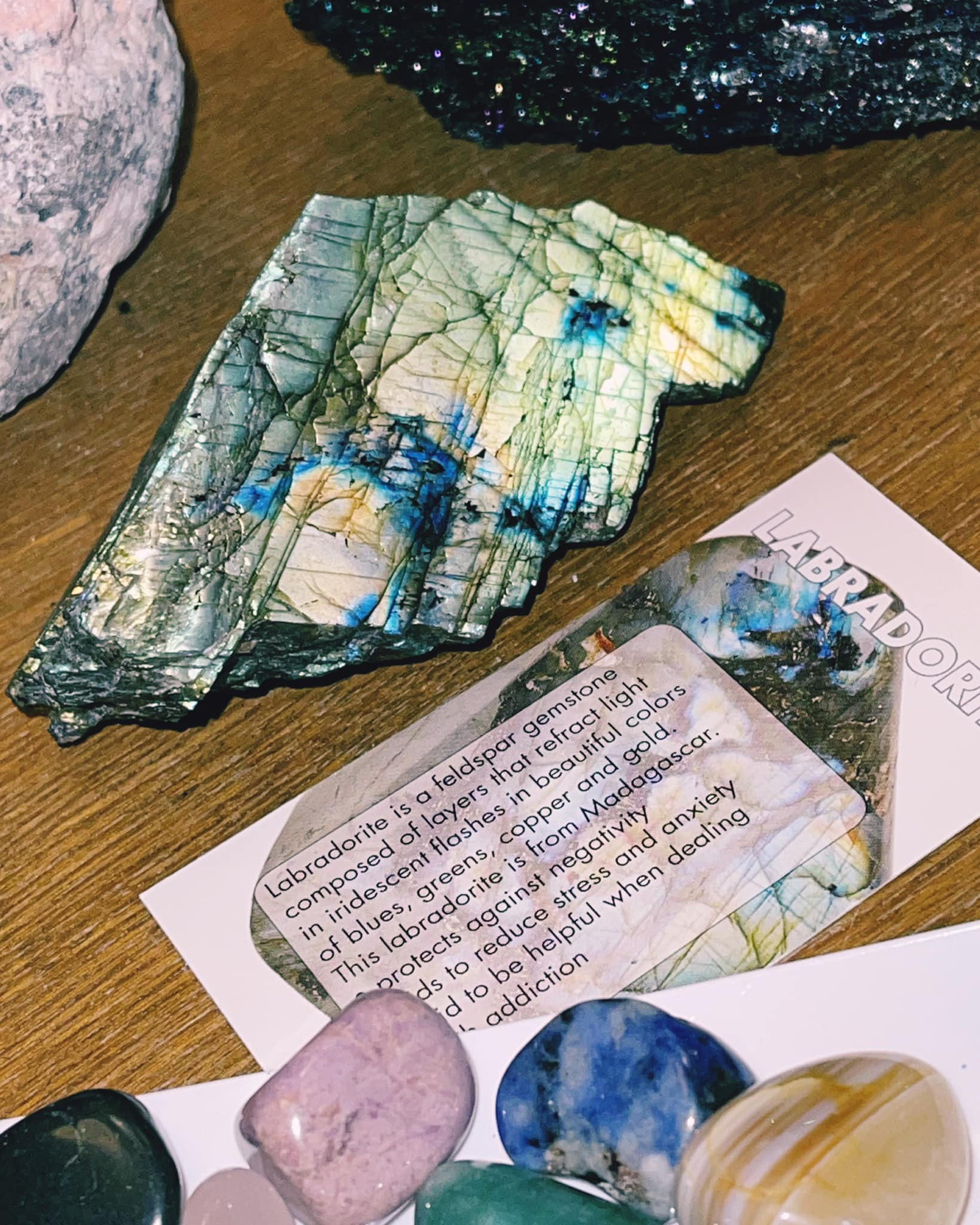 Assorted crystals and stones on a table beside a handwritten note card.