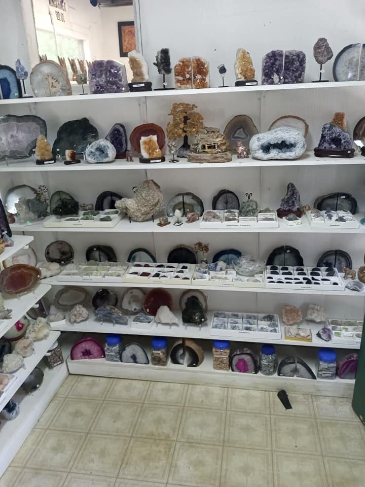 Shelves of assorted crystals and mineral geodes displayed in a shop