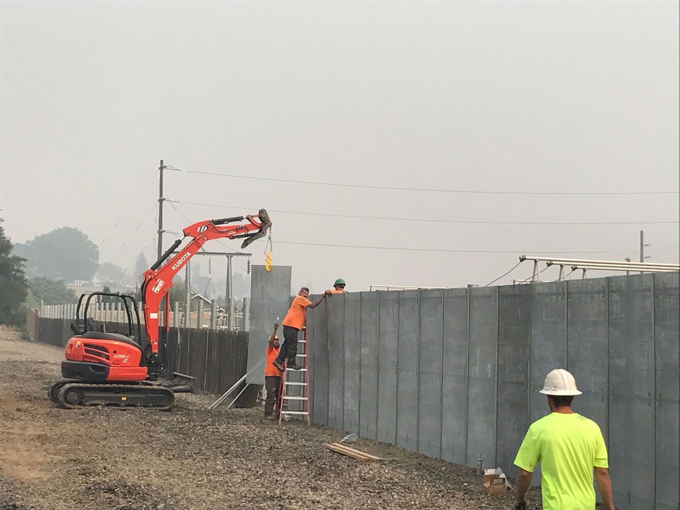 Join Our Team A group of construction workers are working on a fence.