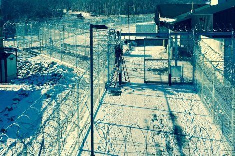 A barbed wire fence is surrounded by snow