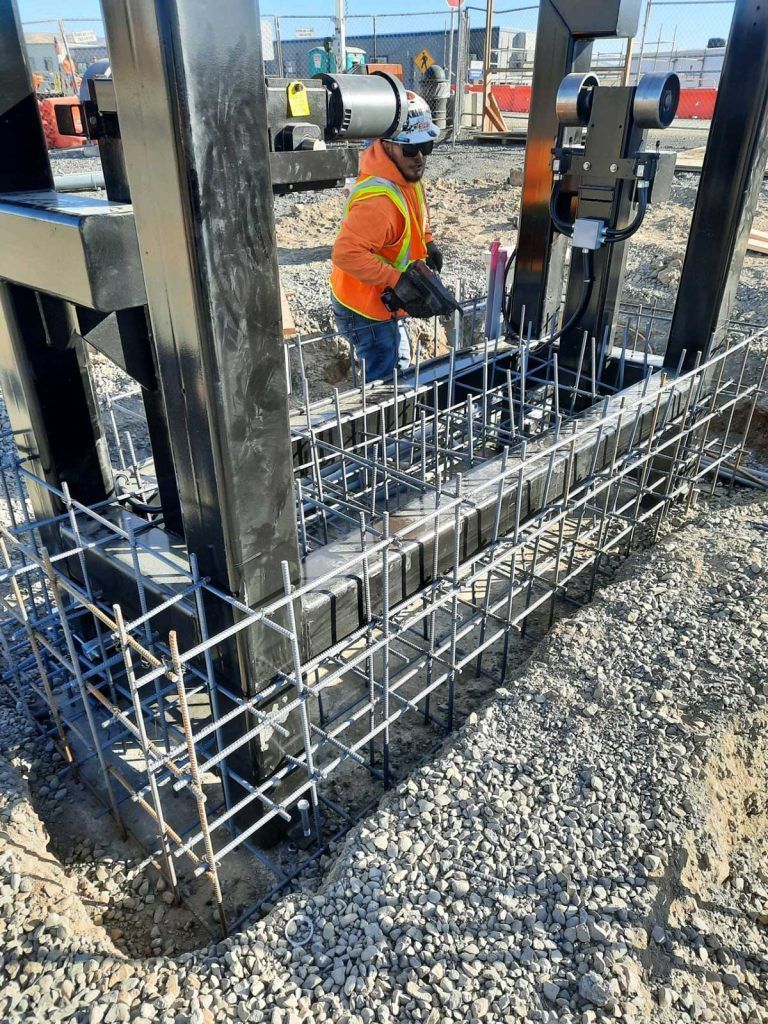 A construction worker is working on a metal structure on a construction site.