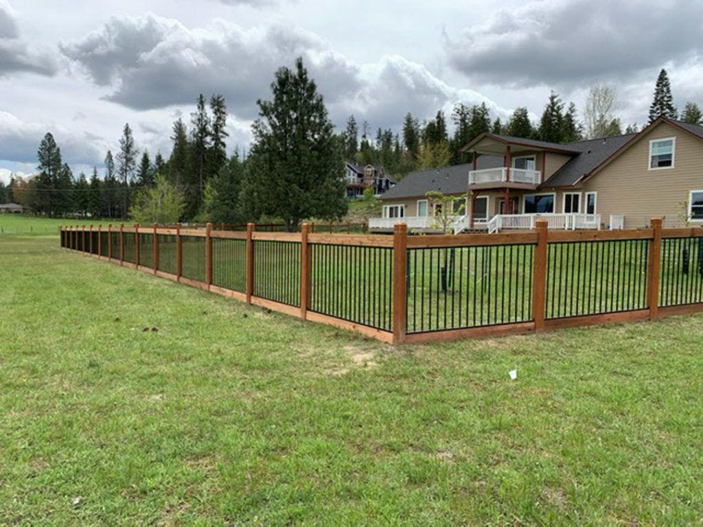A large house with a wooden fence in front of it.