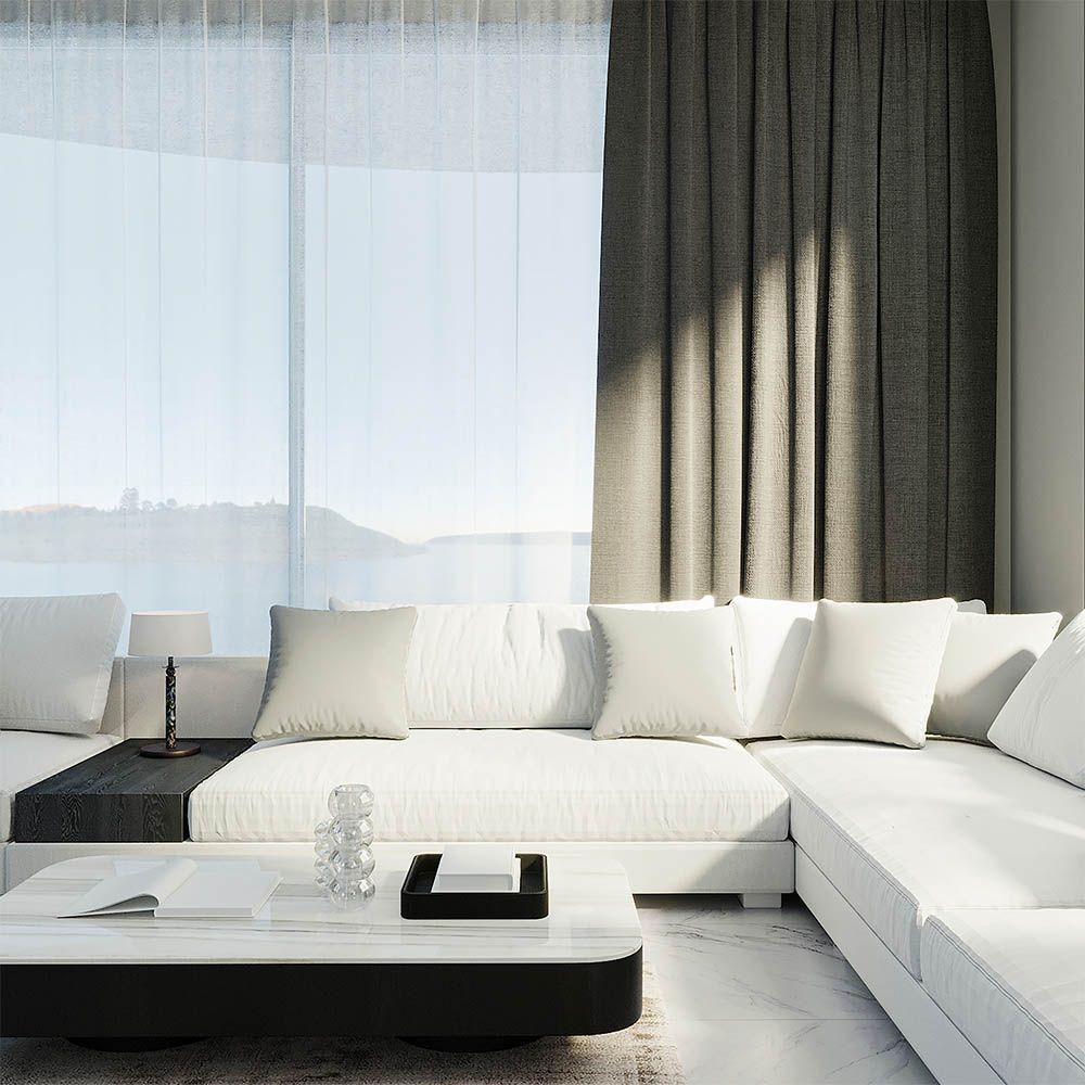 White sectional sofa next to window with gray curtains; coffee table in modern living room.