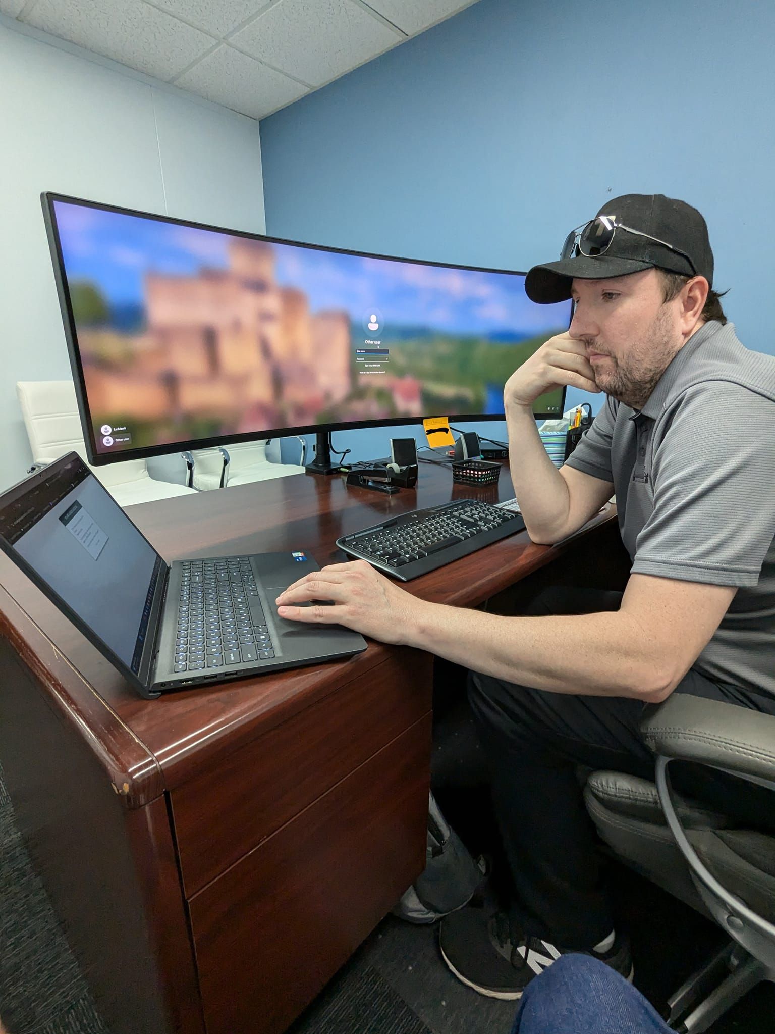 A man is sitting at a desk using a laptop computer.
