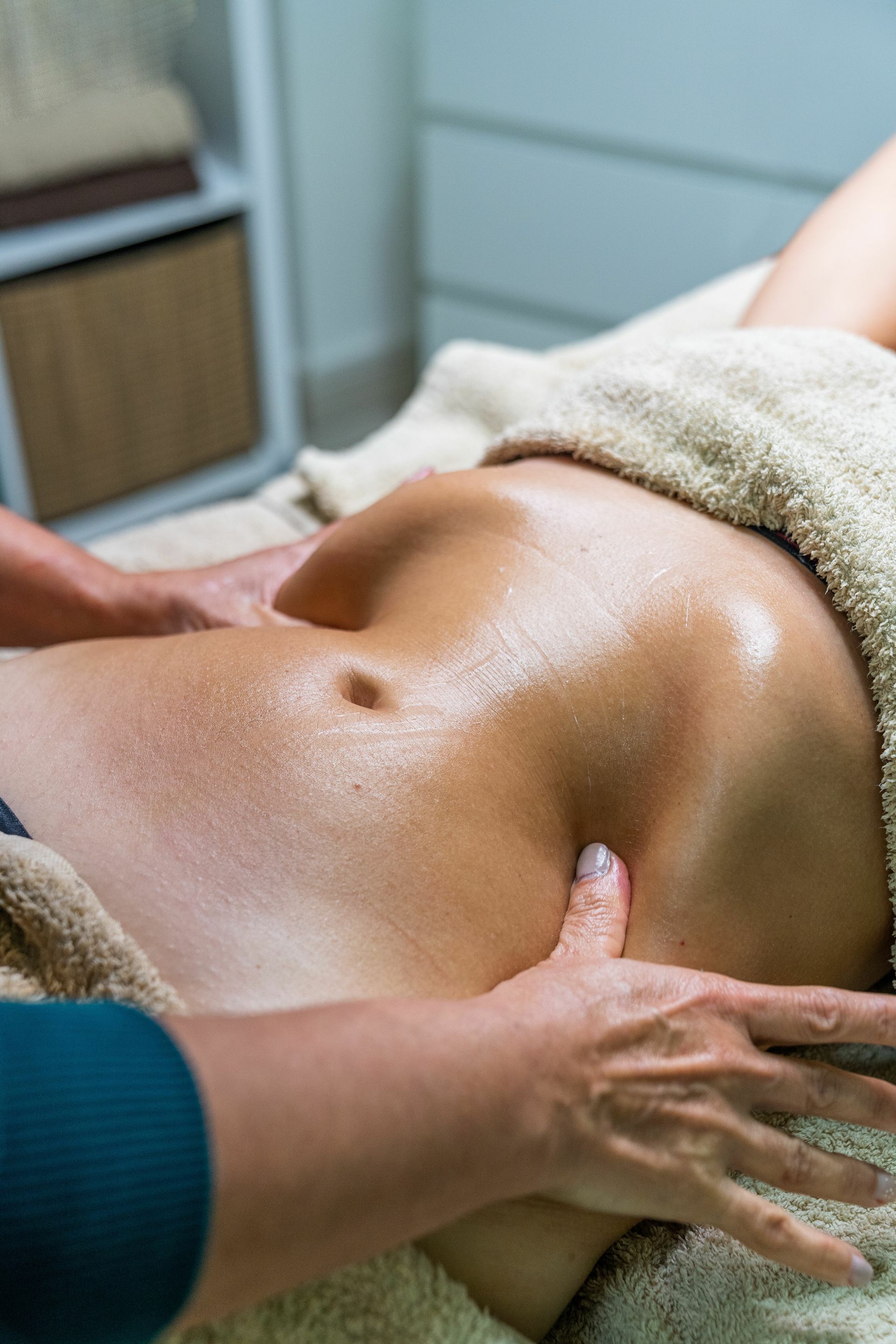A woman is getting a massage on her stomach in a spa.