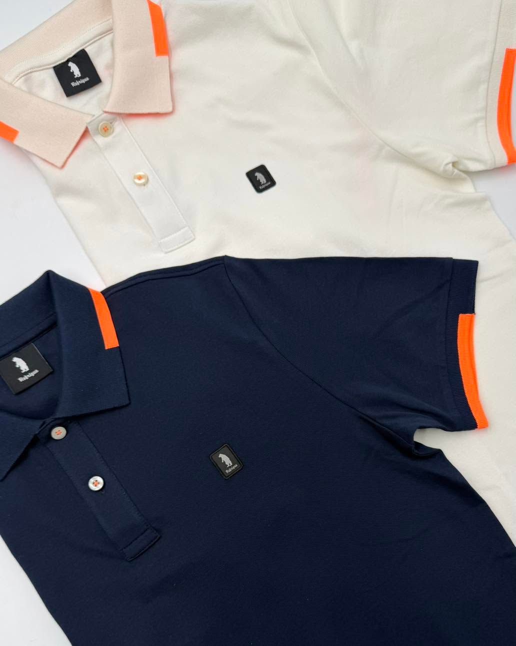 Due polo, una bianca e una blu navy, con bordi arancioni su sfondo chiaro