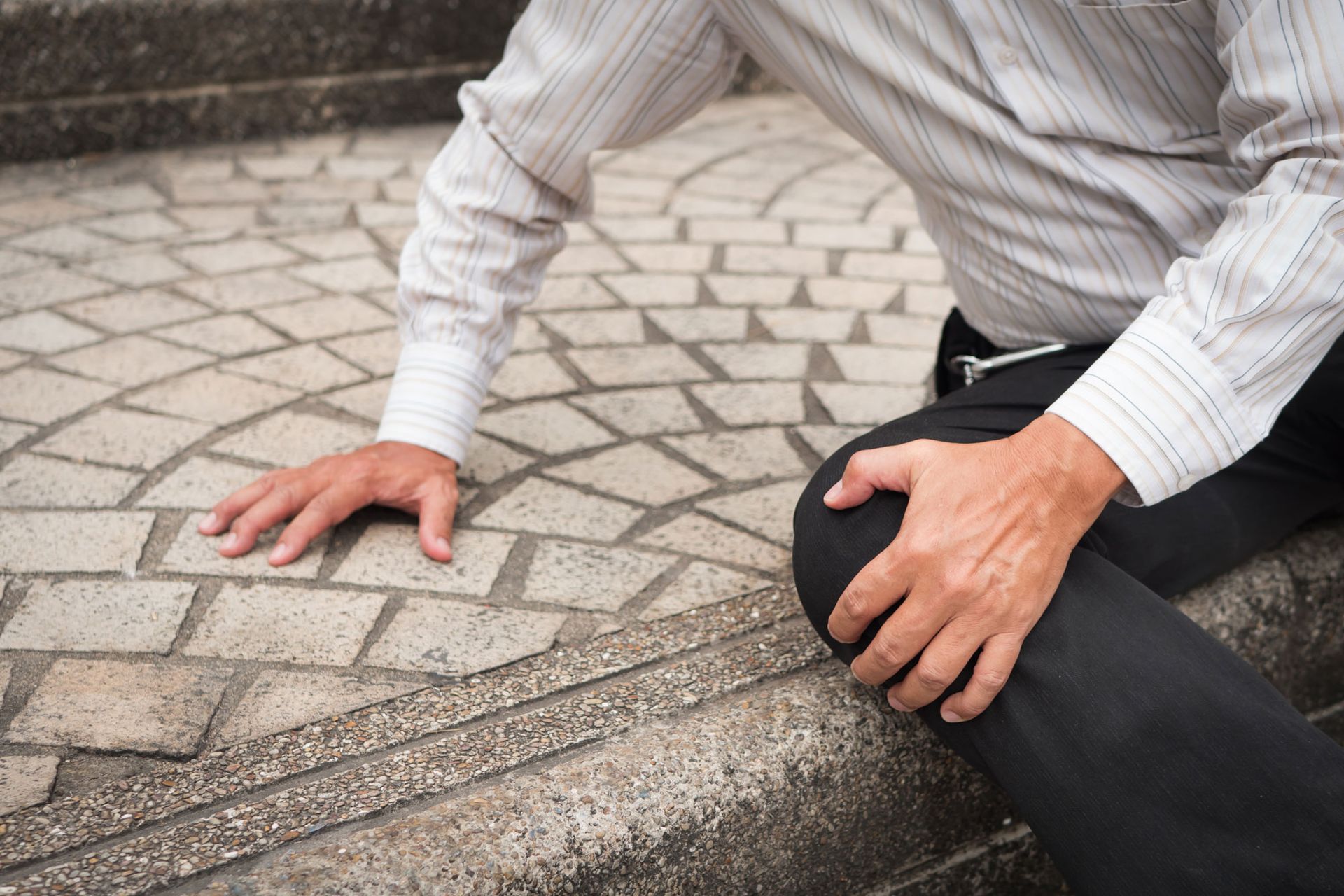 old senior man falling down holding knee