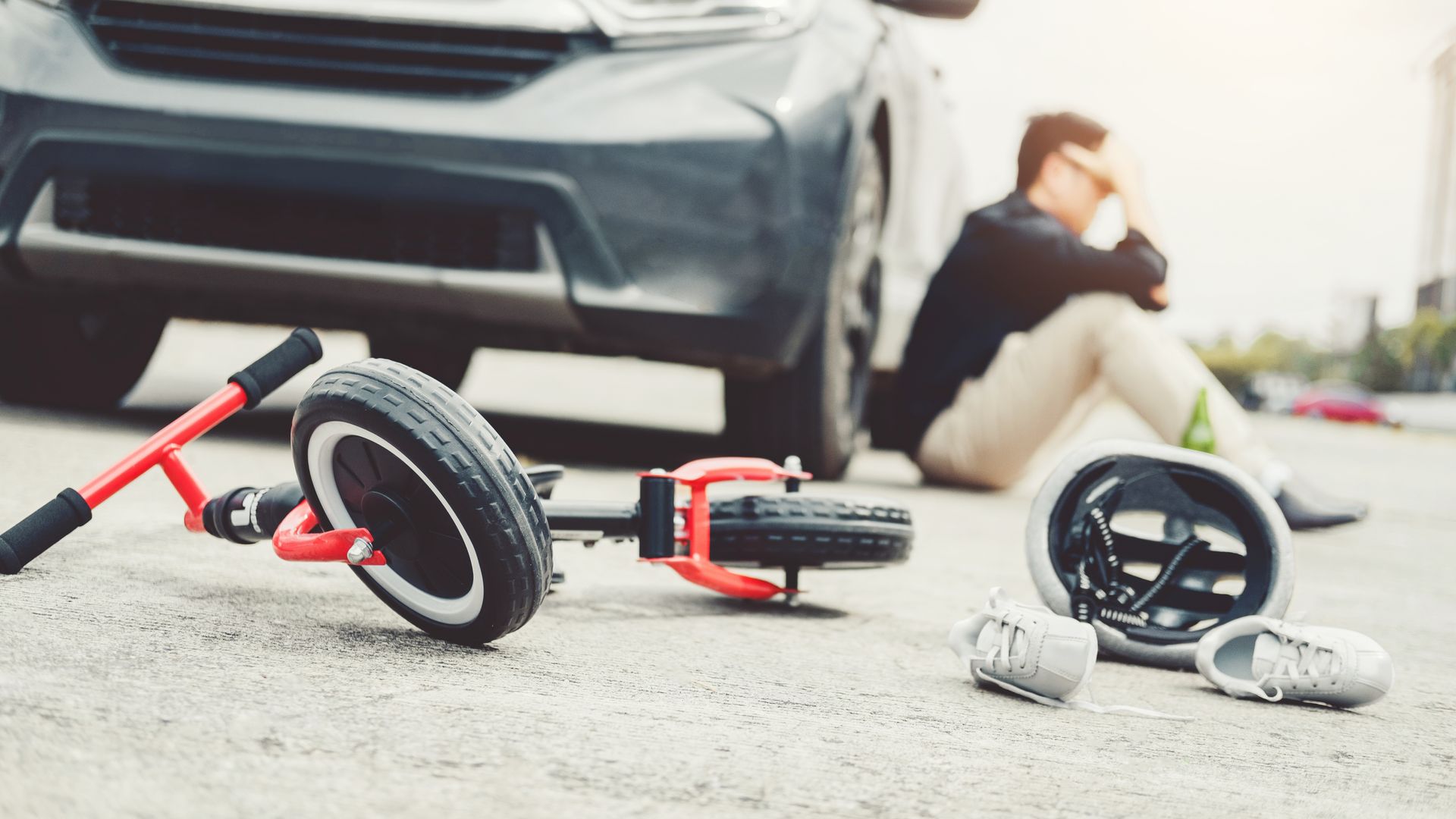 Stressed man suffering after accident car crash with children's bicycle