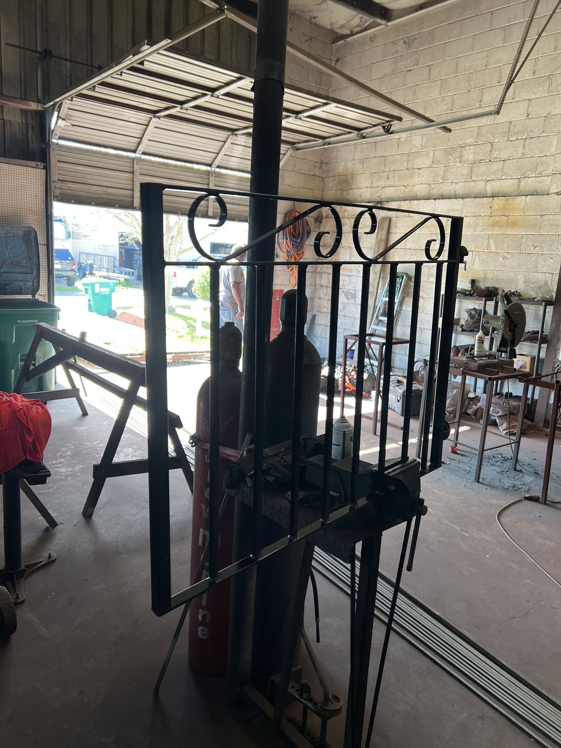 A wrought iron gate is being built in a garage.