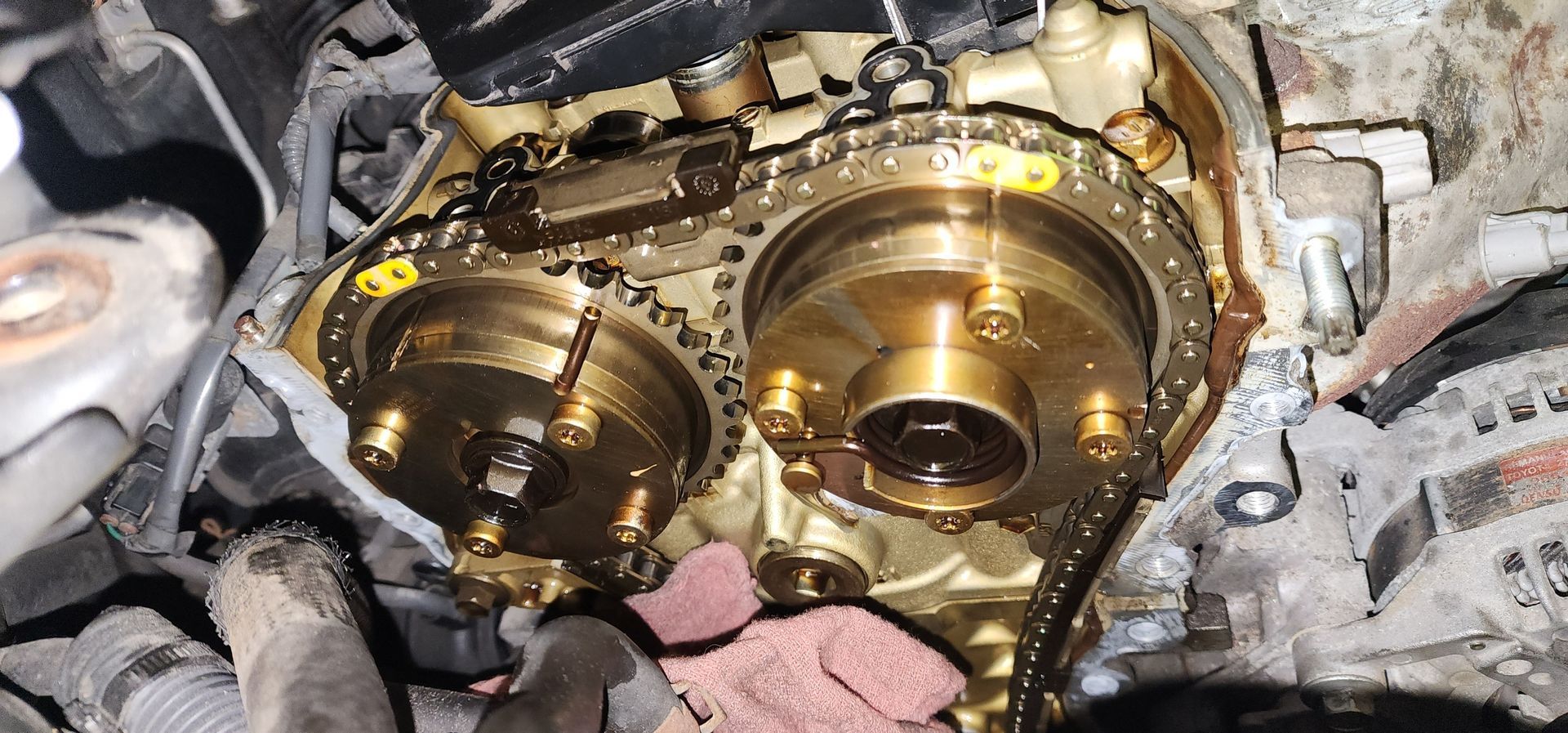 A close up of a chain on a car engine.