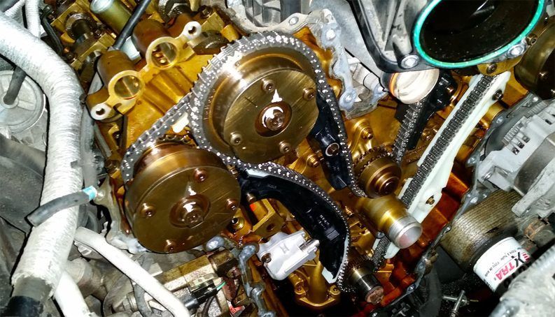 A close up of a car engine with chains on it.