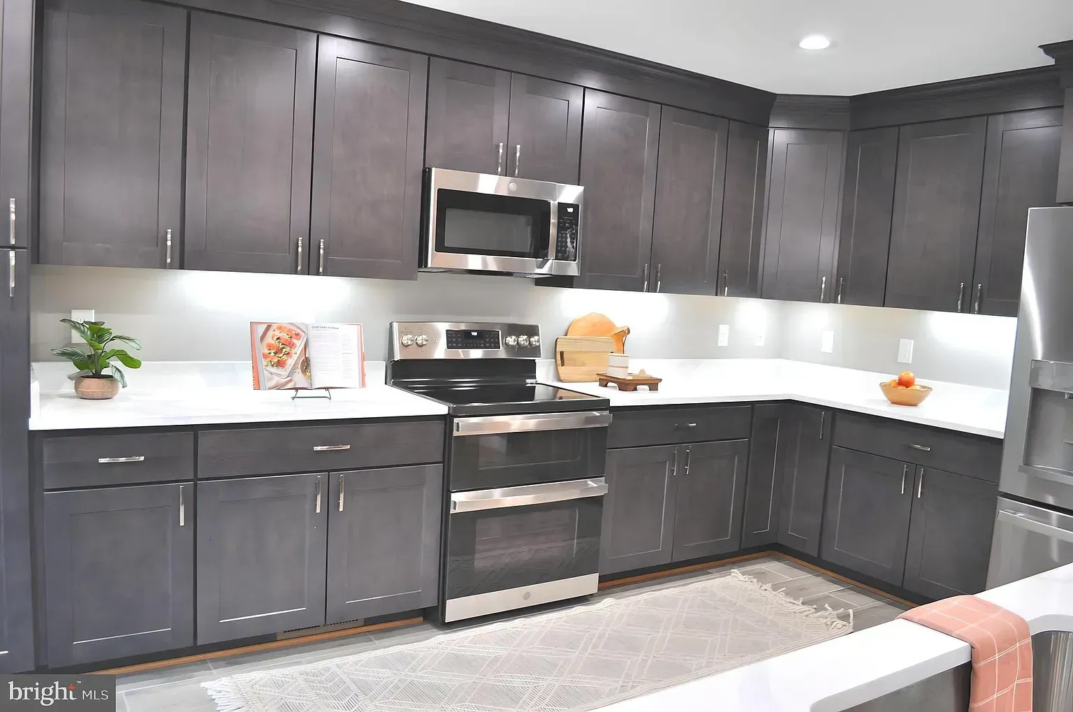 Spacious kitchen with wood cabinets, dark granite countertops, and two islands.