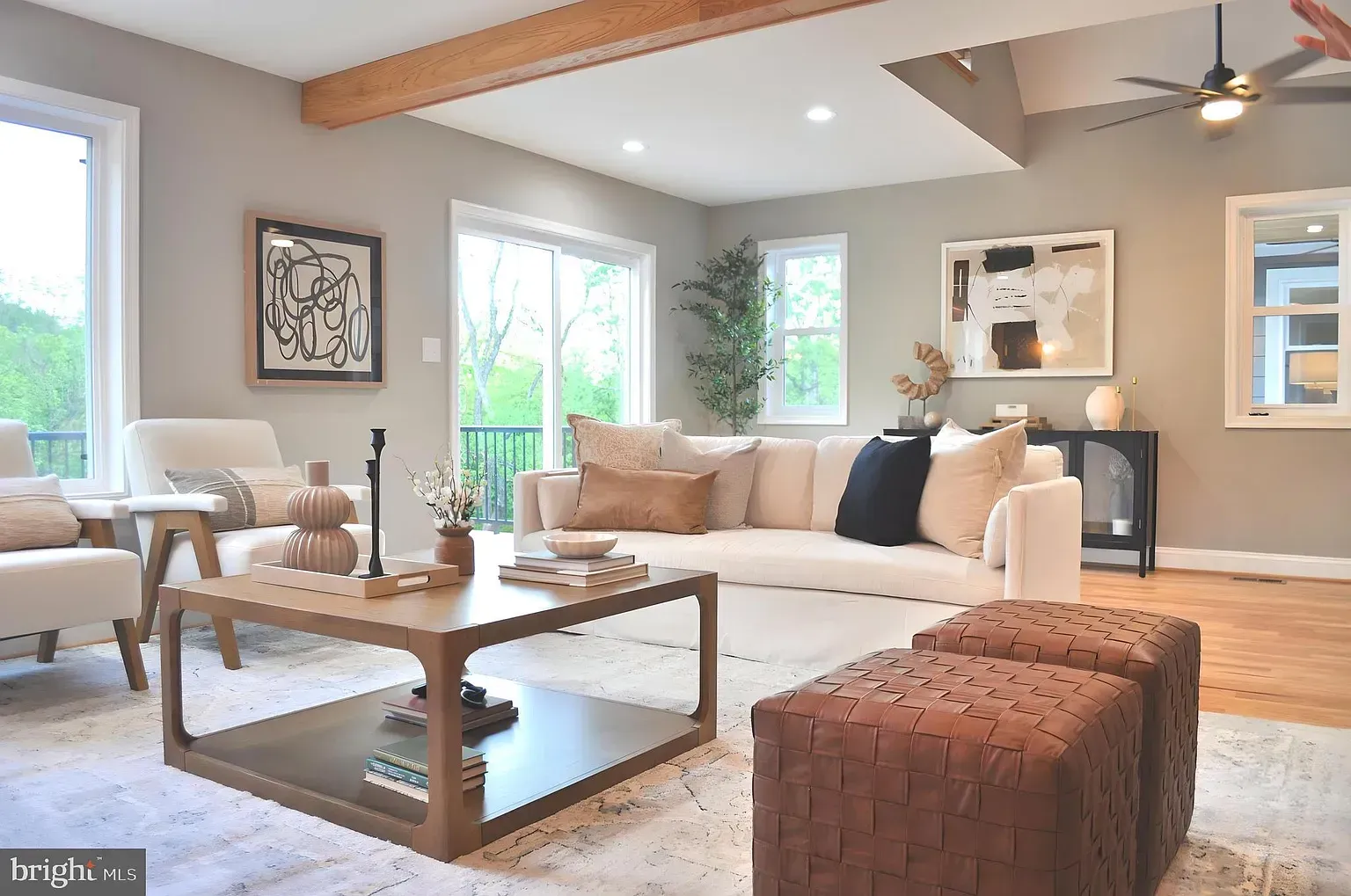Living room with neutral tones, sofa, coffee table, and large windows.
