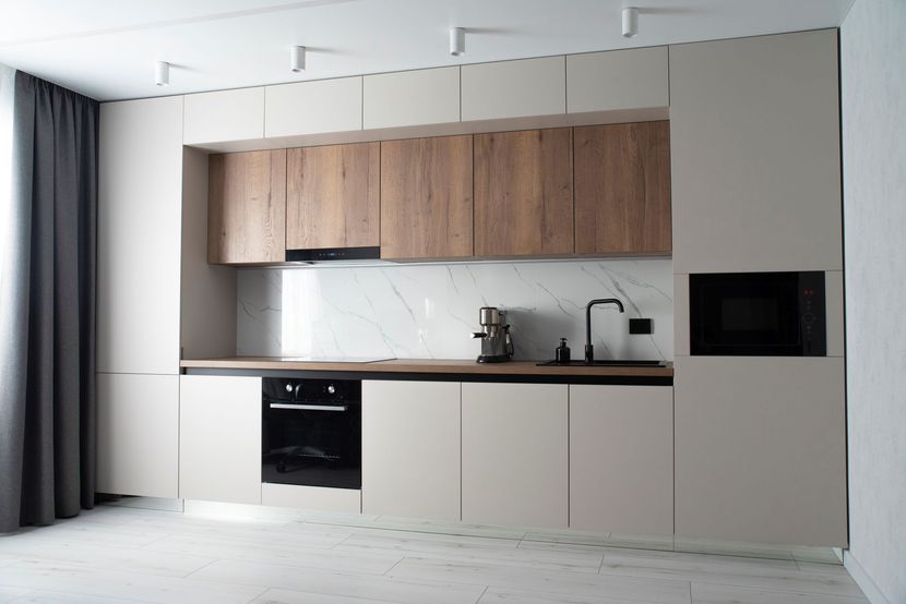 Modern minimalist kitchen with wood cabinets, white lower cabinets, black countertop, and gray curtains. Modern minimalist kitchen with wood cabinets, white lower cabinets, black countertop, and gray curtains.