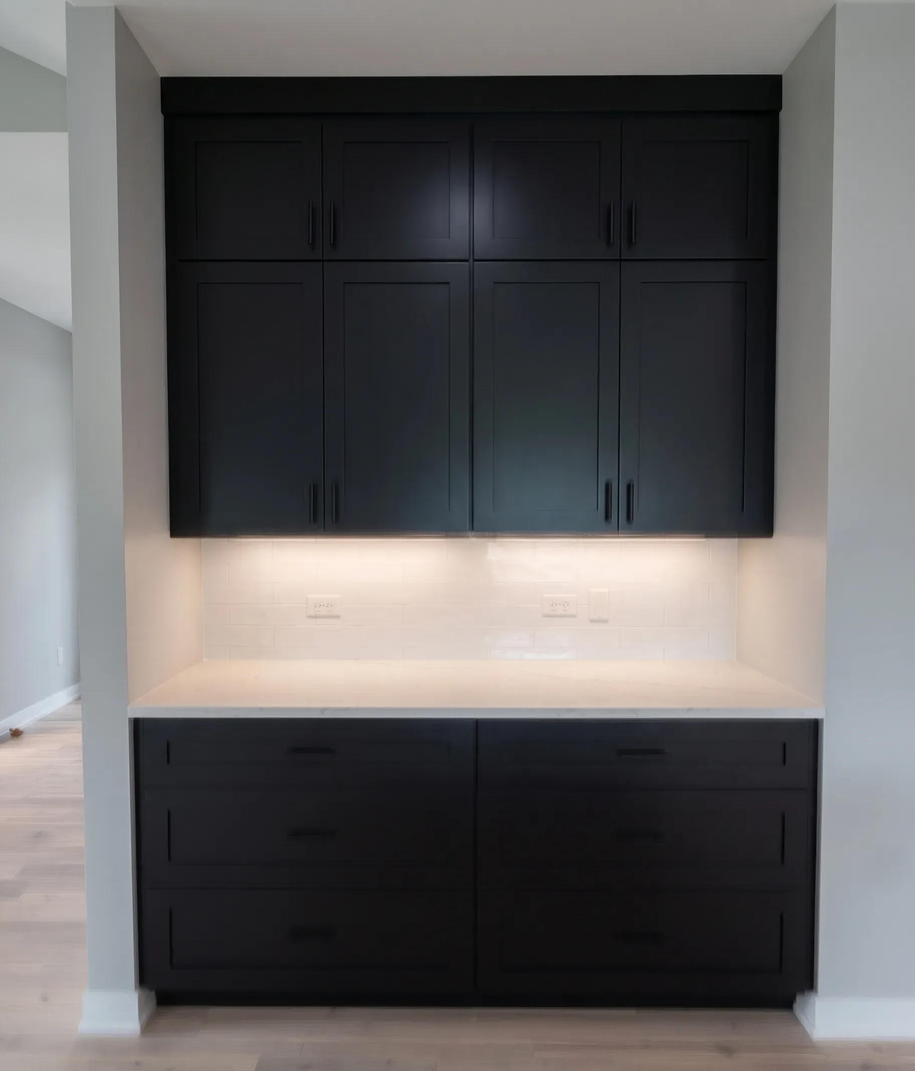 Built-in black cabinets with under-cabinet lighting in a modern alcove.