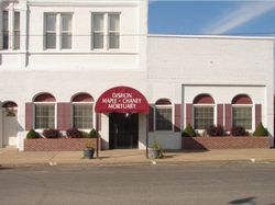 White storefront with red awnings and a red sign reading “Fashion Mart,” viewed from the street.