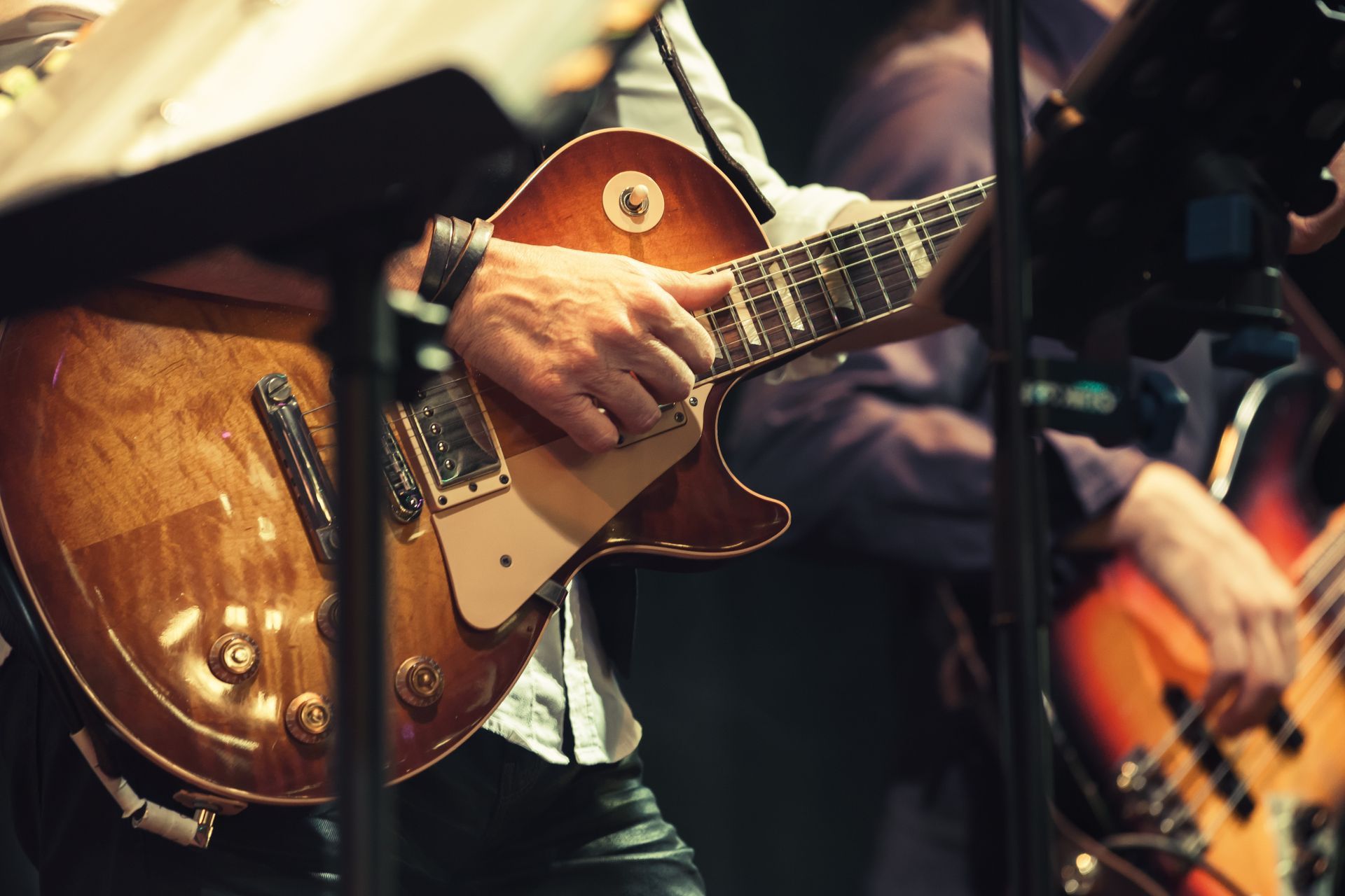 a man is playing an electric guitar in front of a microphone .