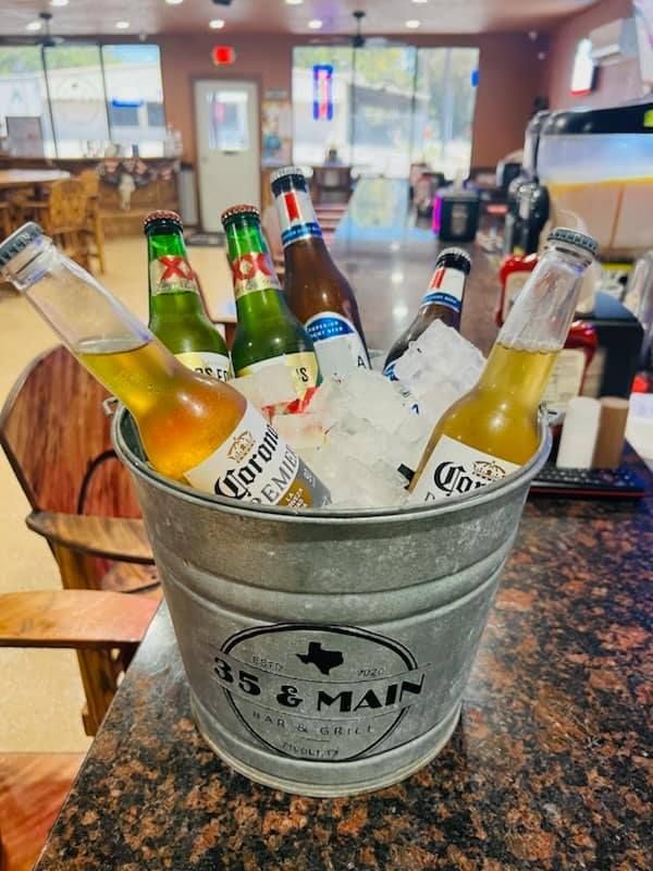 a group of people are toasting with beer in a bar .
