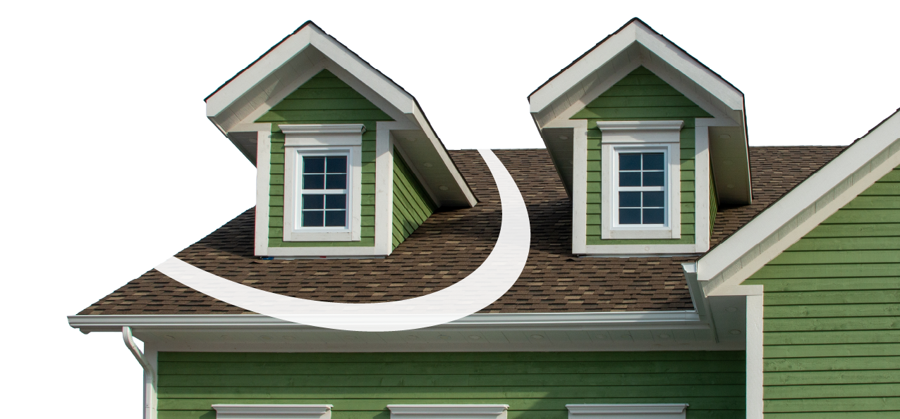Green house with dormer windows on brown shingled roof, white trim.
