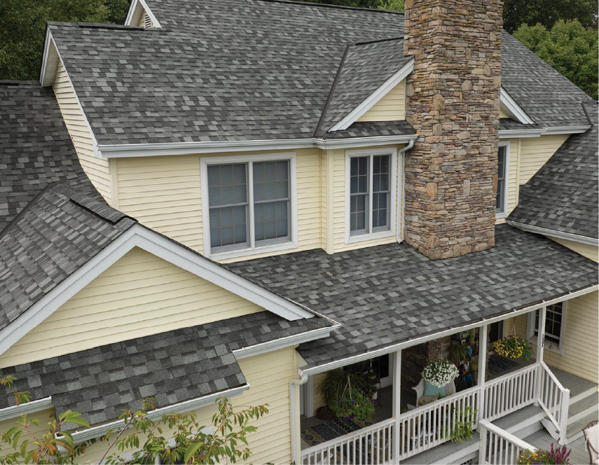 Yellow house with gray shingle roof, chimney, and white porch.