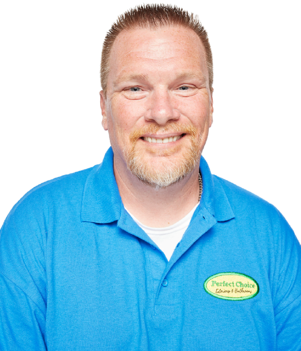 Man in a blue polo shirt smiling at the camera against a white background.
