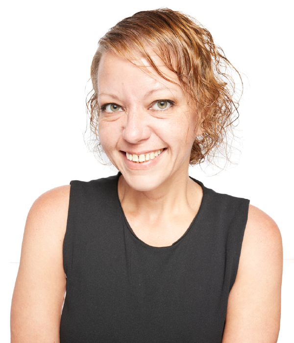 Woman smiling in a black sleeveless top against a white backdrop.