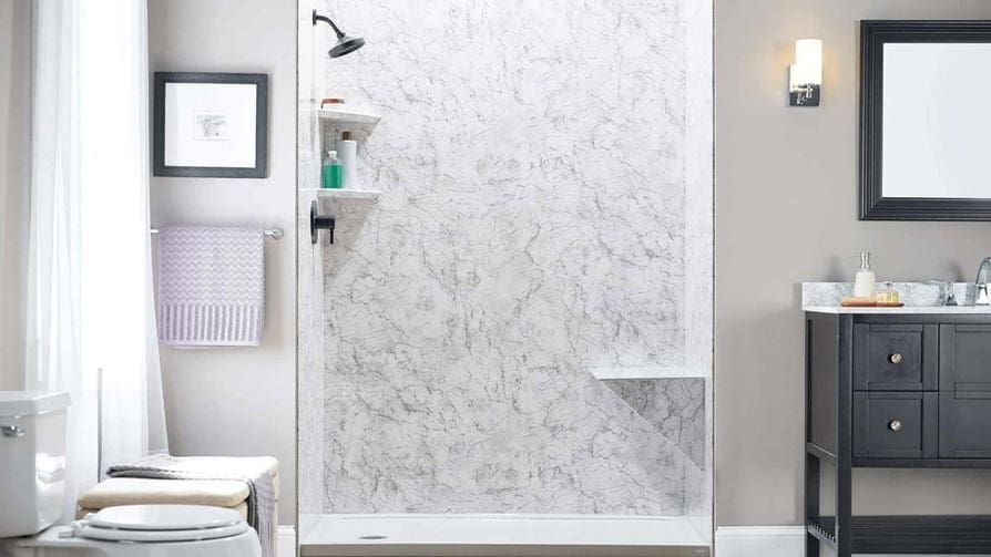 Bathroom with marble-look shower, white walls, and dark vanity. Includes shelves, a seat, and a window.
