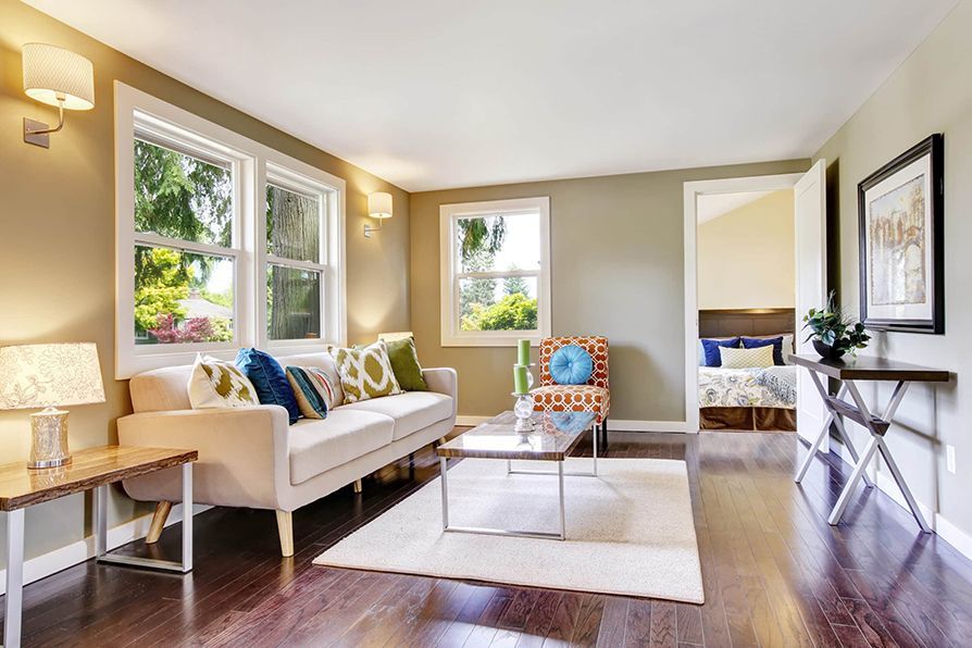 Living room with sofa, chair, and coffee table, in a house with wood floors.