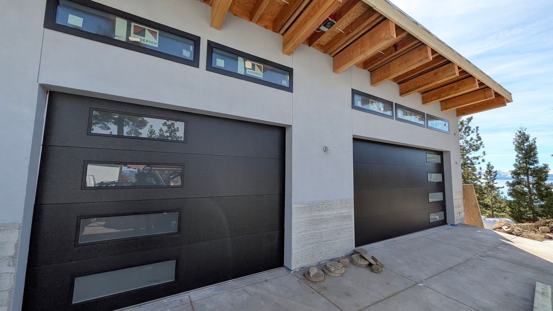 Industrial building exterior with two roll-up doors, portable toilet, and concrete lot