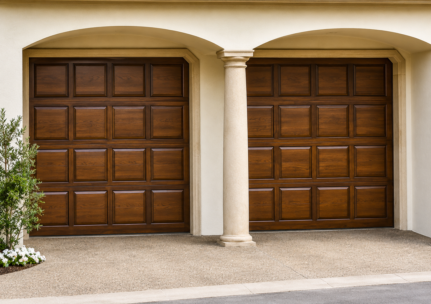 Two wooden garage doors beneath beige arches, with a white column between them.