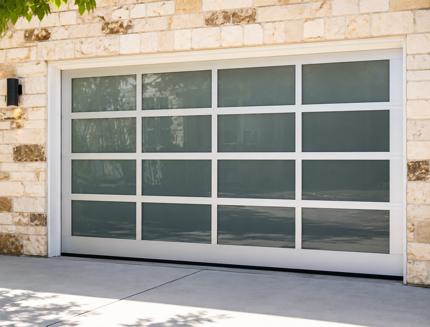 White garage door with frosted glass panels set in a stone exterior wall.