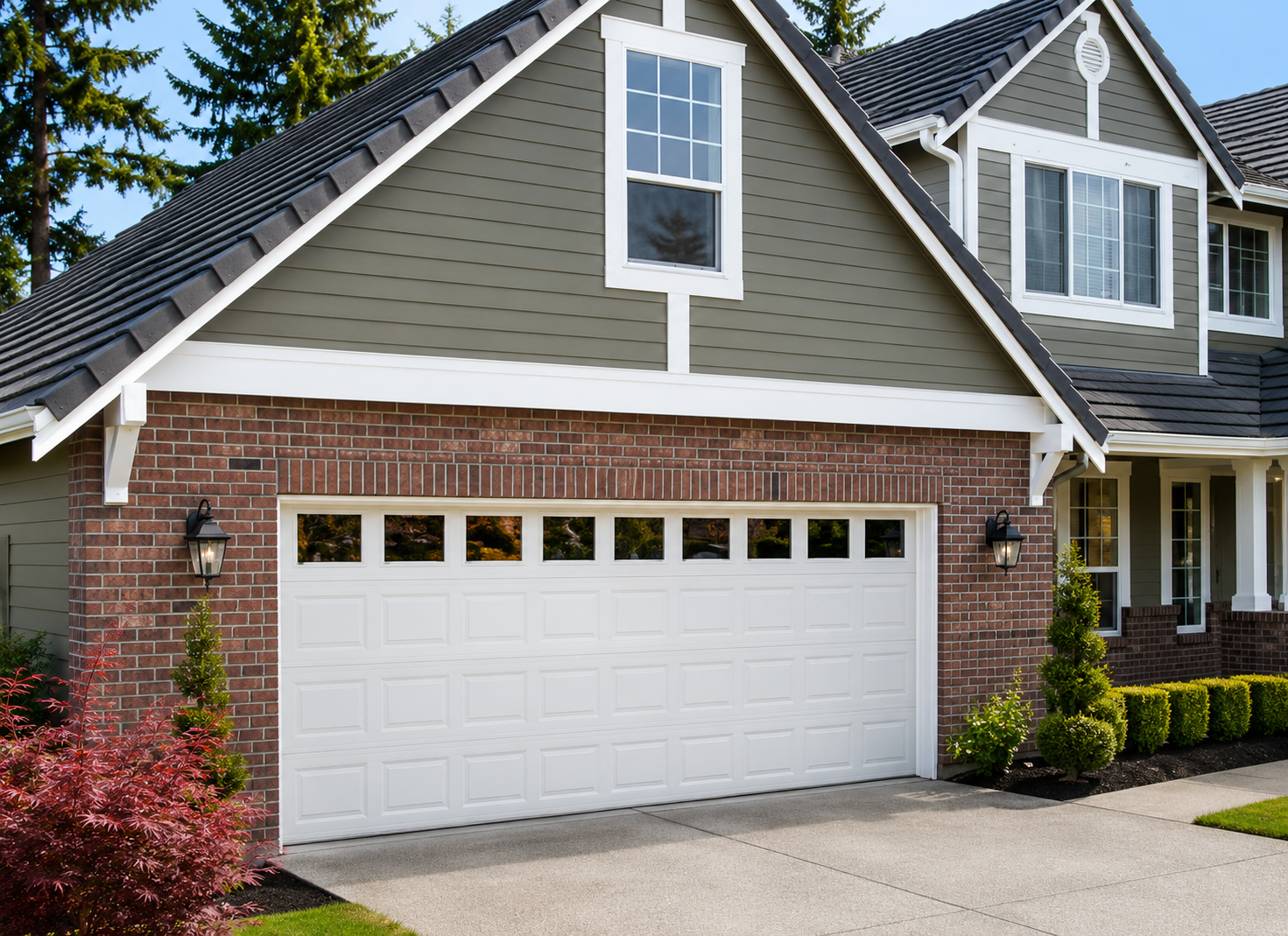 Suburban house with brick garage, white door, and gray shingled roof under blue sky
